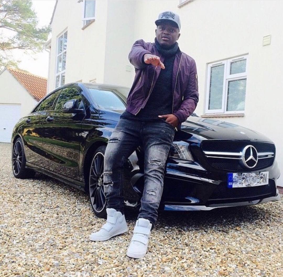 2018-08-21-Victor Wanyama: Kenyan Celebrity Chilling While Leaning On Bonnet Of His AMG Black Mercedes Benz Car